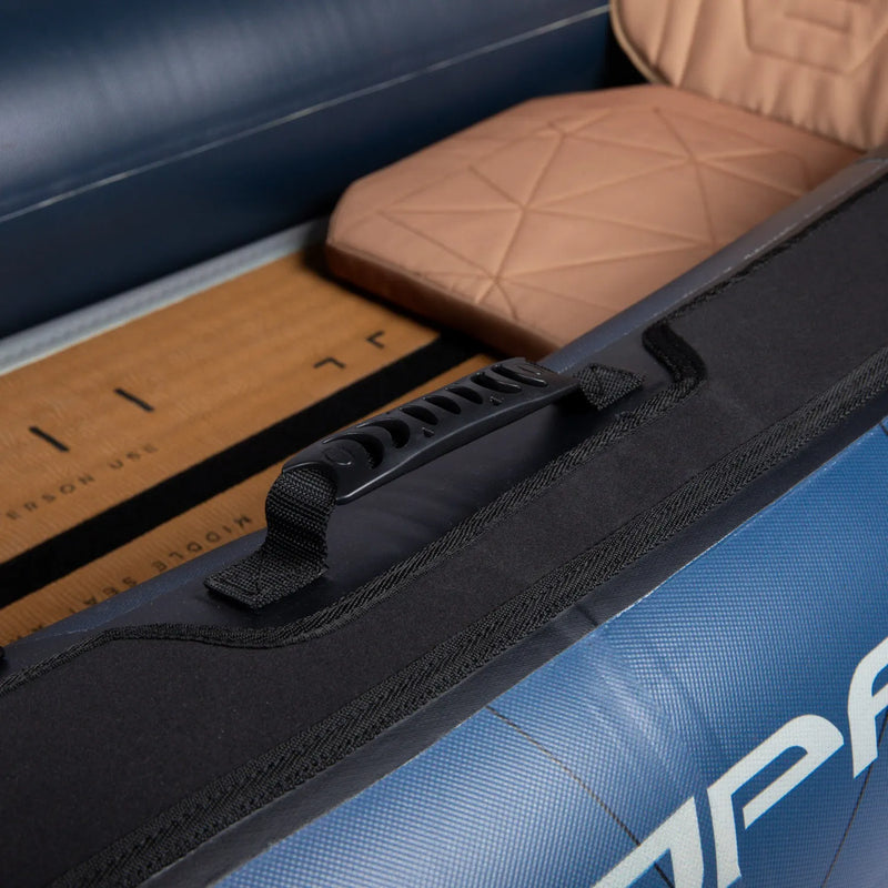 Close-up of a black handle on a blue kayak with a ruler for scale.
