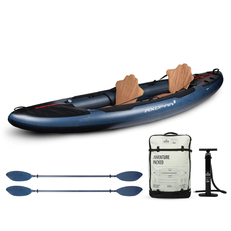 Blue kayak with wooden seats, two paddles, a white bag labeled 'Adventure Packed', and a black pump on a white background.