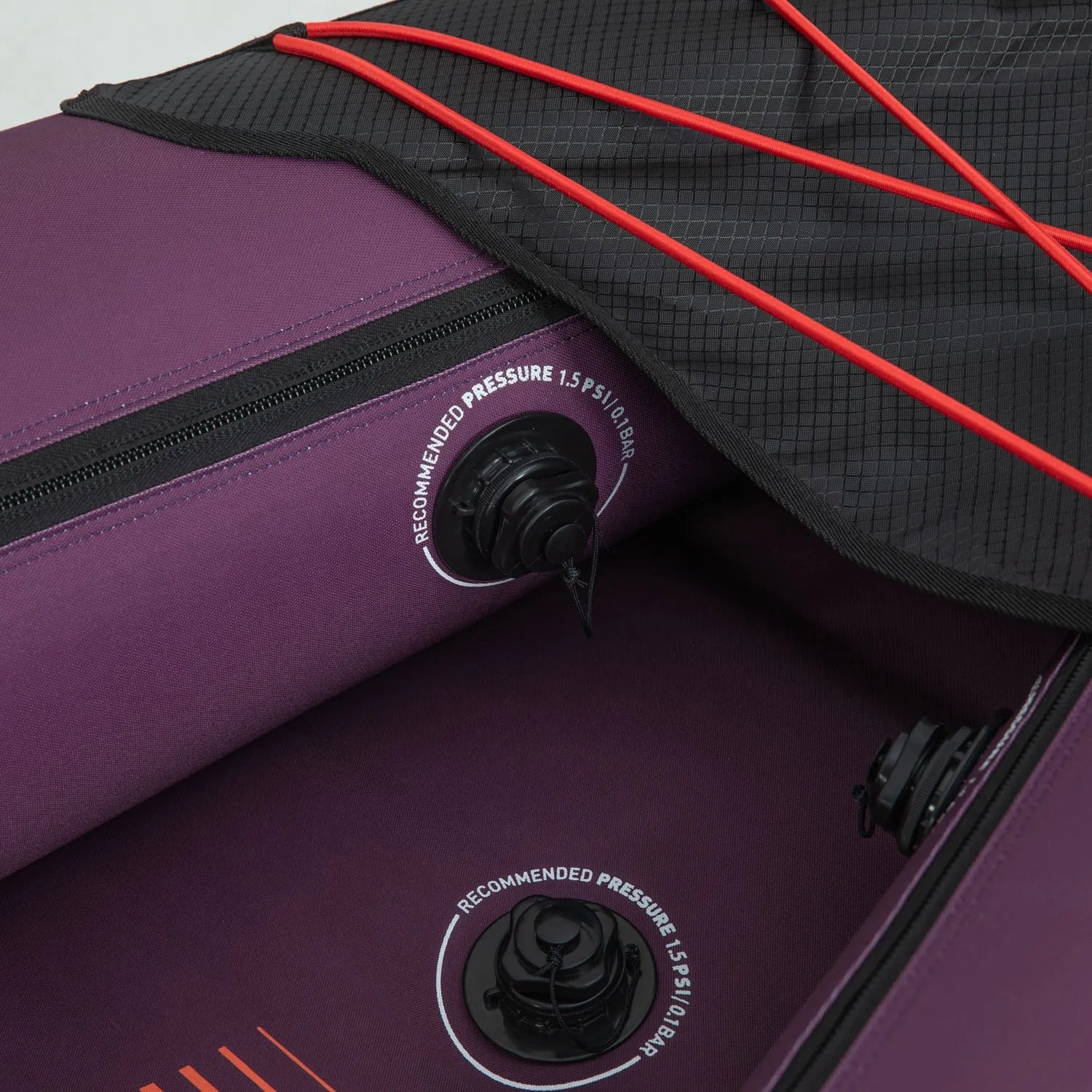 Close-up of a purple inflatable kayak with red straps and valve details.