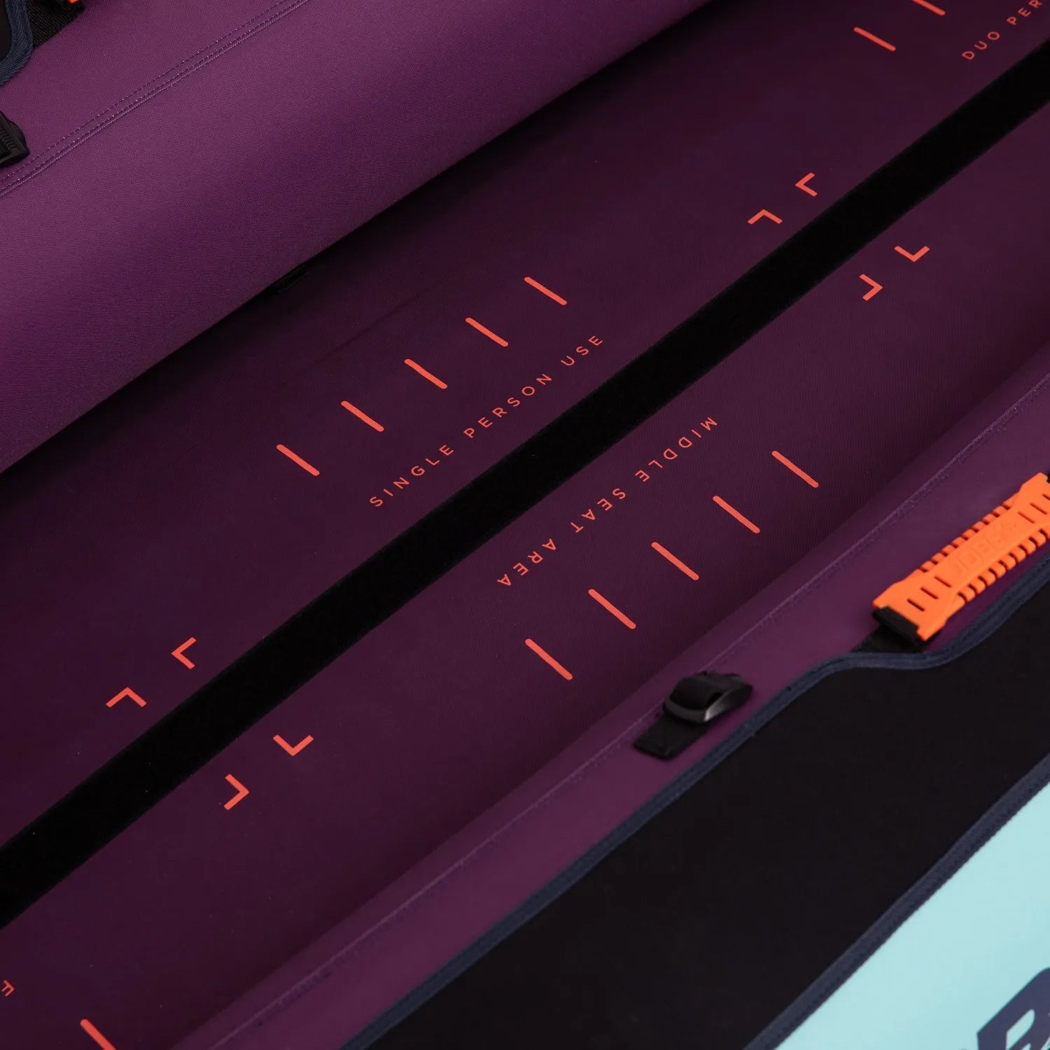 Close-up of a purple suitcase with orange text and accents