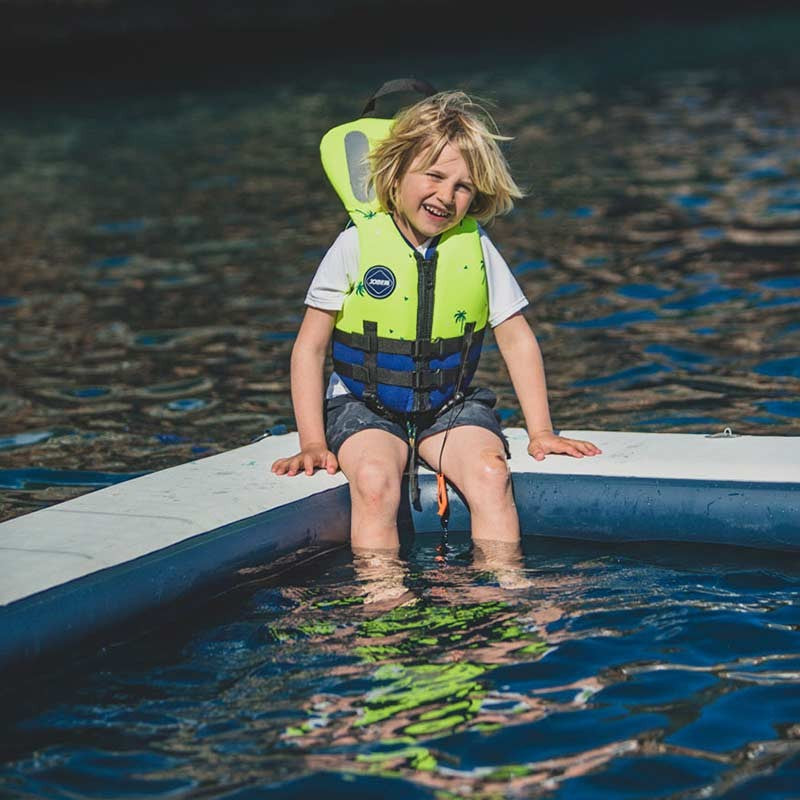 A bright green JOBE neoprene safety life vest for kids with adjustable webbing straps, a front zipper, and reflective panels.